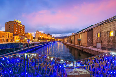 Illuminated buildings against sky at night