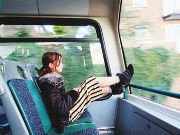 Side view of girl sitting in train