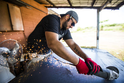 Worker using angle grinder to cut steel.