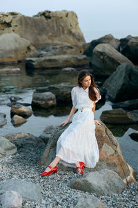 Side view of woman sitting on rock