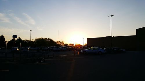 Cars parked on road at sunset