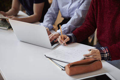 Students using laptop and taking notes