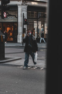 Full length of man walking on street in city