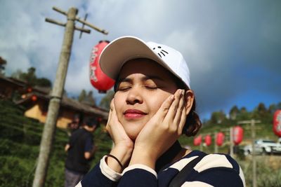 Close-up of woman with eyes closed wearing cap during sunny day
