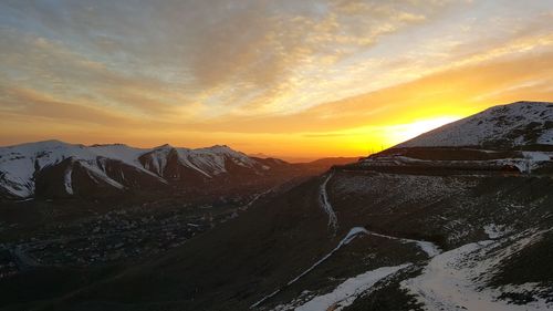 Scenic view of snowcapped mountains against sky at sunset