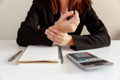 Midsection of woman sitting on table