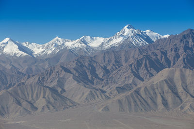 Scenic view of snowcapped mountains against clear blue sky