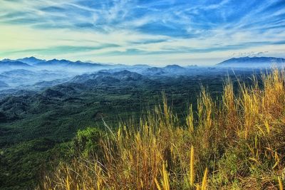 Scenic view of land and mountains against sky