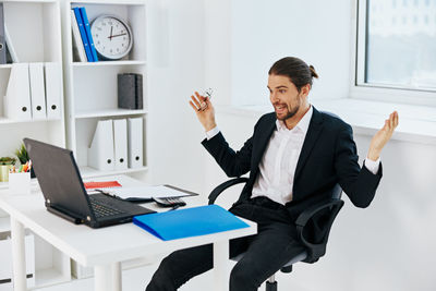 Young man using mobile phone while sitting on table