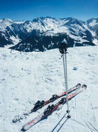 Skis and poles in snow against sky