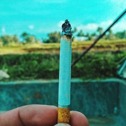 Close-up of hand holding cigarette