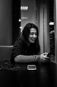 Portrait of smiling young woman using smart phone