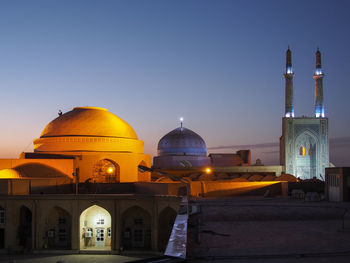 Illuminated building against clear sky