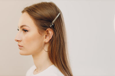 Close-up of young woman against white background