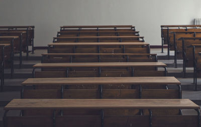 Empty chairs and tables in row