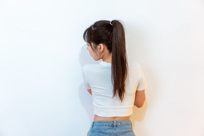Rear view of woman standing against white background