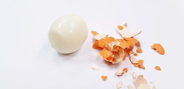 High angle view of broken egg over white background