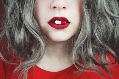 Close-up of woman with capsule in mouth