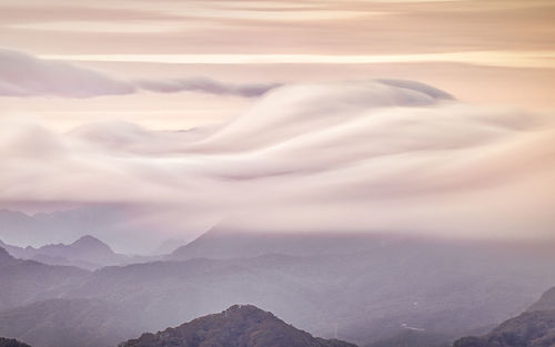 Scenic view of snowcapped mountains against cloudy sky