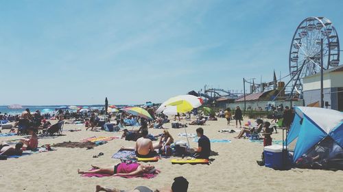 People at beach against sky