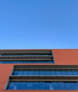 Low angle view of modern building against clear blue sky