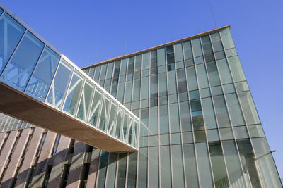 Low angle view of modern building against clear blue sky