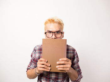 Portrait of young man wearing mask against white background