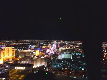 Illuminated cityscape against sky at night