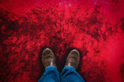 Low section of man standing on red rock