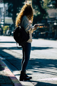 Woman with umbrella standing on street