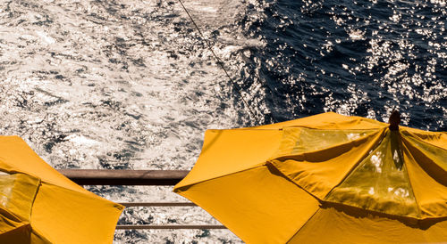 High angle view of yellow umbrella by sea