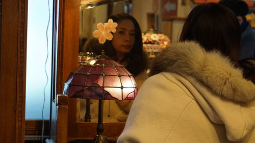 Woman looking in mirror at home