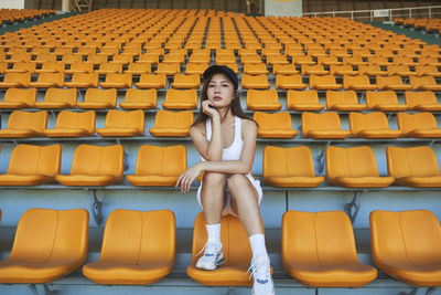 Full length portrait of woman sitting on chair