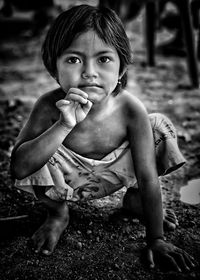 Portrait of cute girl sitting on land