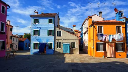 Houses by street in town against sky