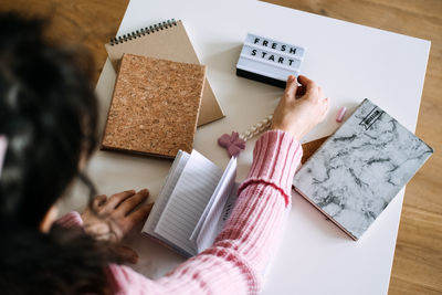 High angle view of woman reading book on table