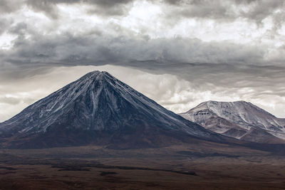 Scenic view of snowcapped mountain against cloudy sky