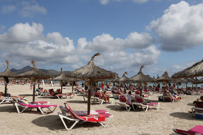 Chairs on beach against sky