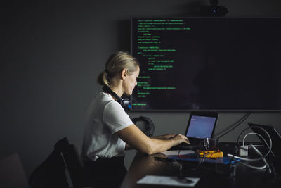 Female it professional typing on laptop in creative office