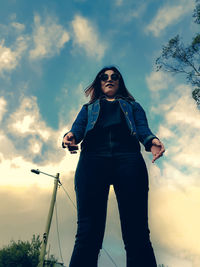 Low angle view of woman standing against sky