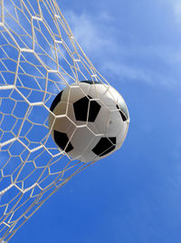 Low angle view of soccer ball against blue sky