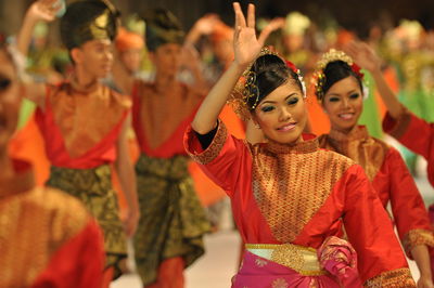 Smiling artists performing traditional dance during carnival