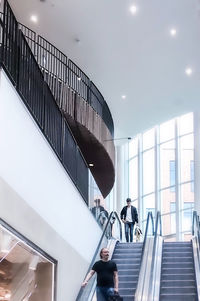 People walking on escalator in modern building