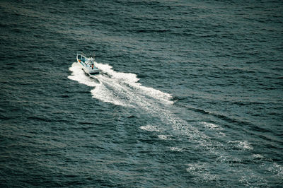 Small fishing vessel heading out to sea in the deep, dark waters of suruga bay.