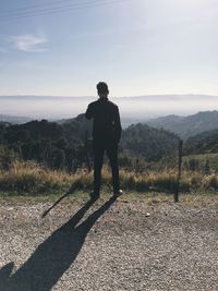 Rear view full length of man standing against mountains