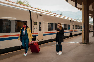 Full length of woman walking on train at railroad station