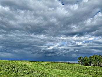 Scenic view of field against cloudy sky
