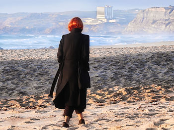 Rear view of woman standing on beach