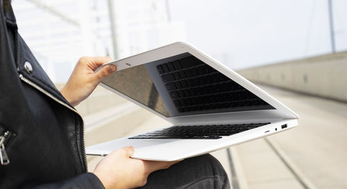 Woman closing her white laptop.