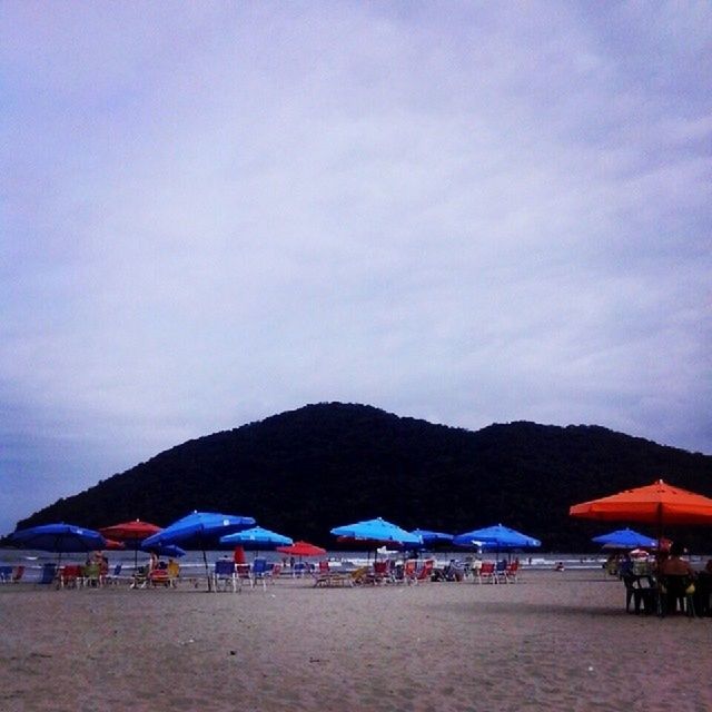 beach, sand, sea, sky, water, shore, vacations, beach umbrella, mountain, parasol, large group of people, scenics, tranquility, tranquil scene, sunshade, tourism, beauty in nature, nature, tourist